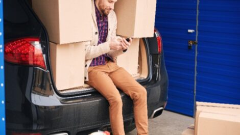 Cardboard boxes stacked inside a car trunk while moving belongings to storage